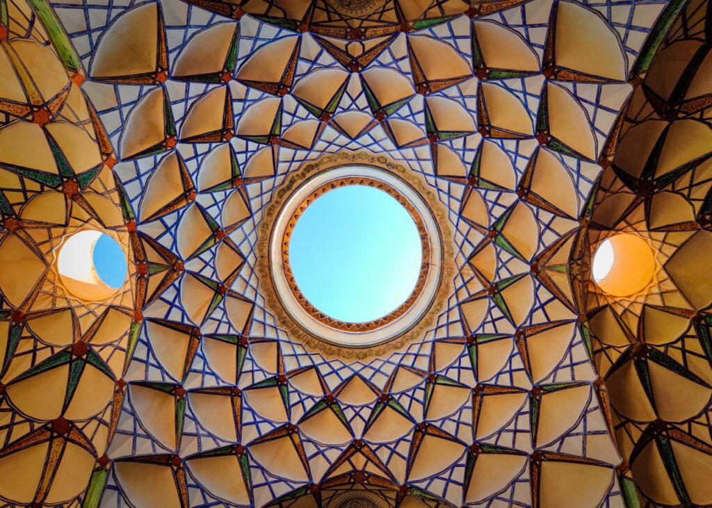 Colorful geometric dome of Persian architecture showcasing intricate designs in Kashan, Iran.
